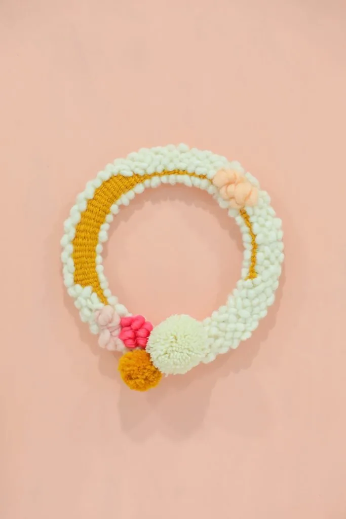 woven yarn spring wreath with pom poms