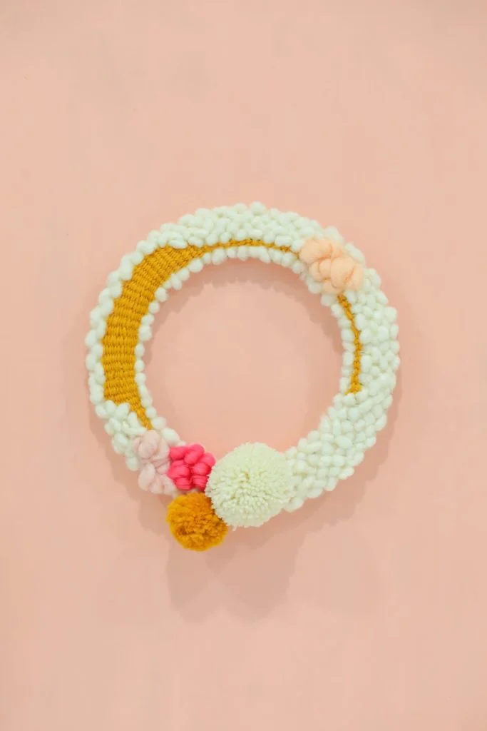 woven yarn spring wreath with pom poms
