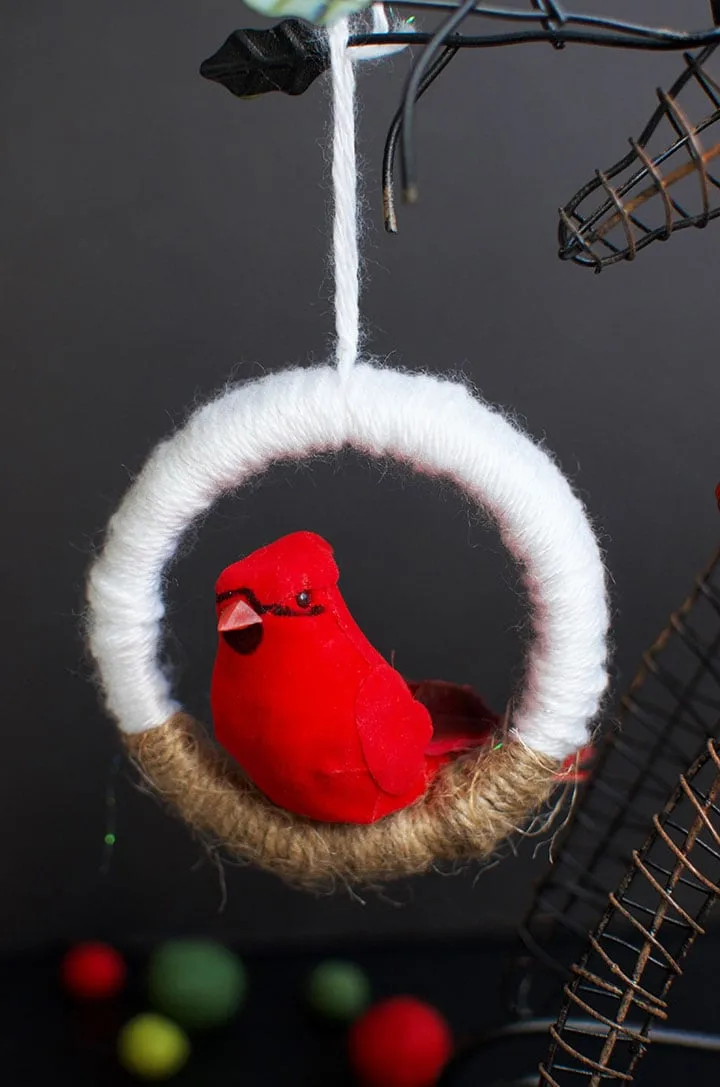 Make this charming and easy DIY Christmas ornament in no time flat using mason jar lids and yarn. You won't believe where I found this perfect bird for the ornaments. Click over to see how to make your own. #DIYChristmas #BirdOrnament #MasonJarLidOrnament