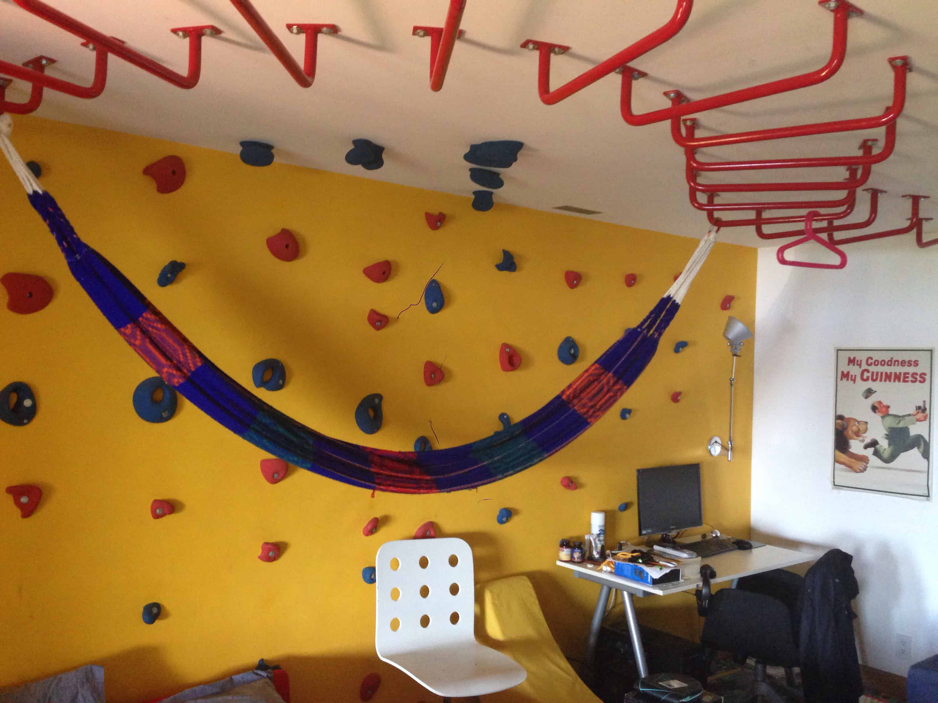 big kids bedroom with climbing wall and monkey bar ceilin