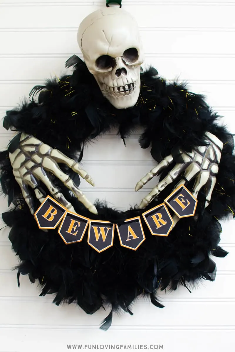 Easy DIY Halloween wreath from Dollar Store finds with free printable banner. #halloween #dollartree #dollarstoredecor #halloweendiy #halloweenwreath #halloweeprintables #funlovingfamilies