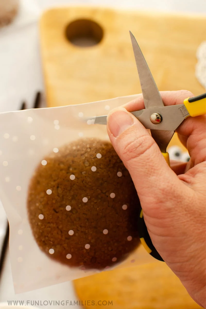 scissors cutting hole in cookie treat bag