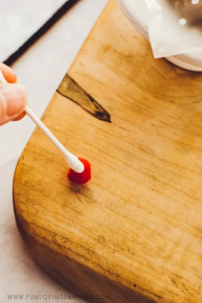 gluing pom pom for reindeer treat bag