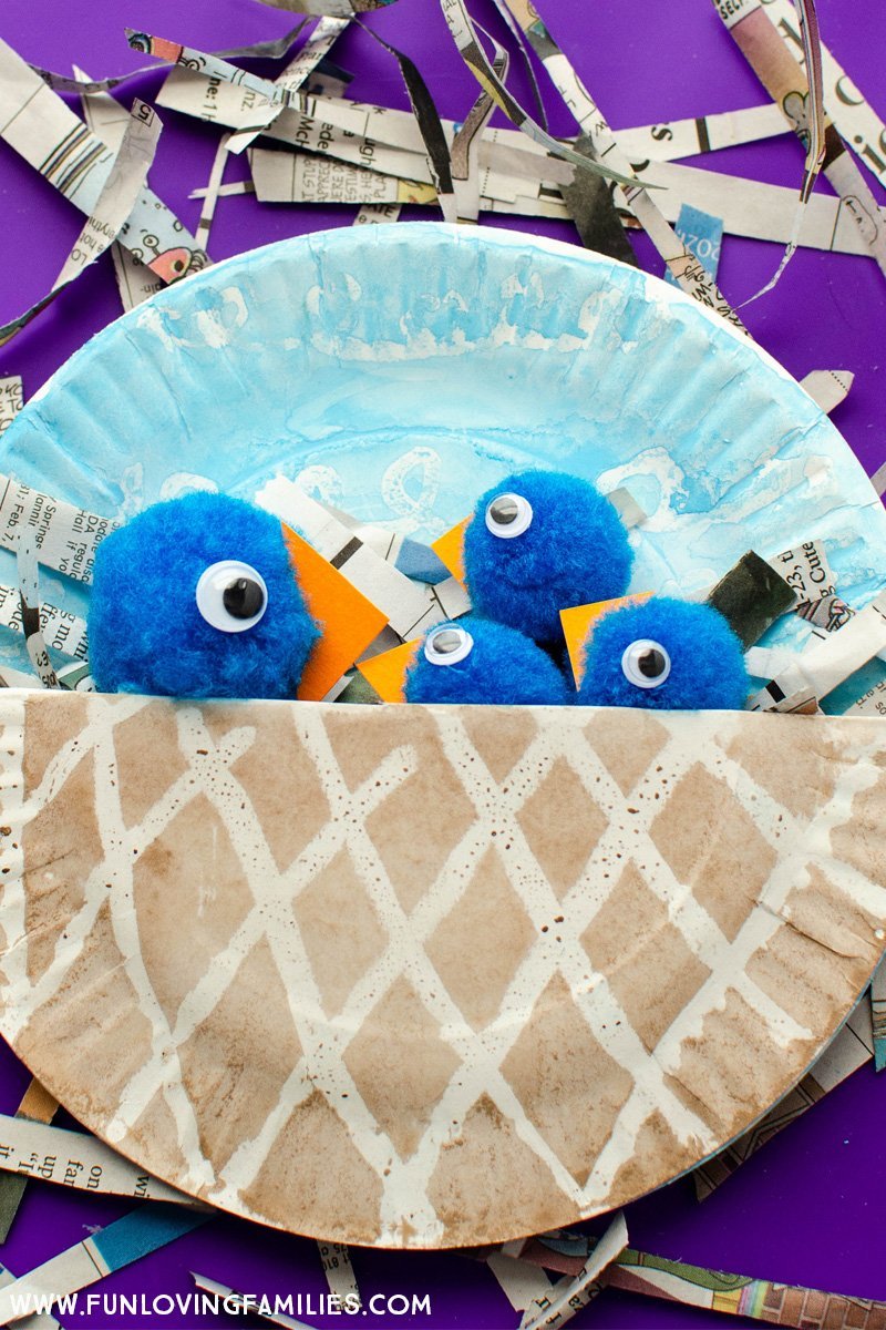 completed paper plate bird nest craft with blue birds