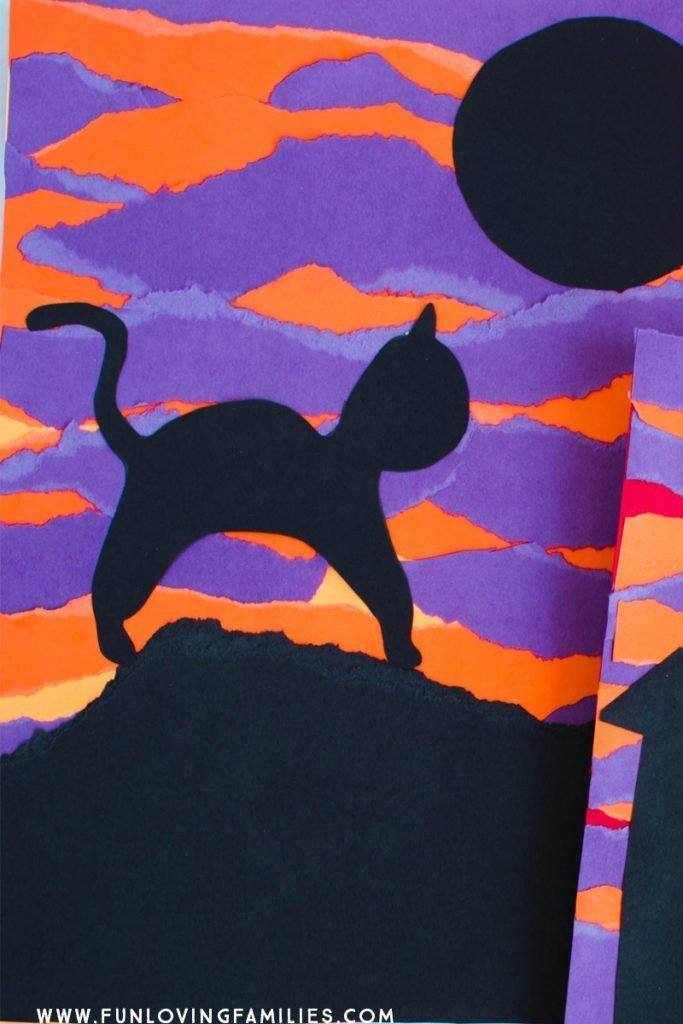 black cat on purple and orange torn paper background