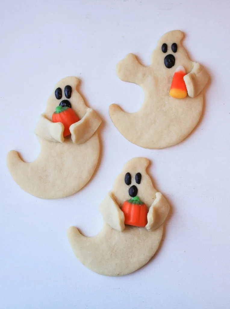ghost cookies holding candy corns