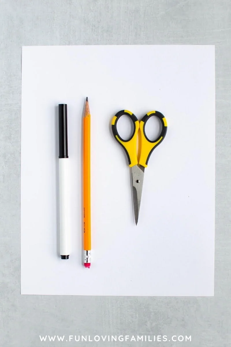 scissors, pencil, and black marker on white paper