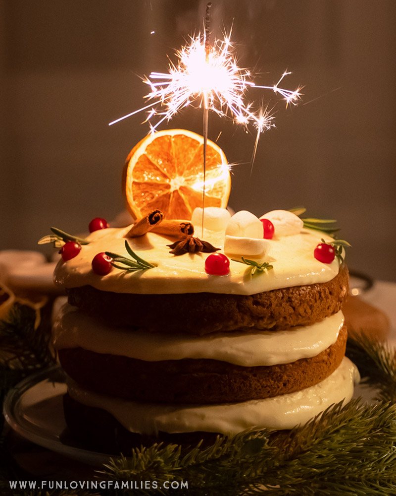 festive Christmas cake with sparkler on a table with fir tree branches