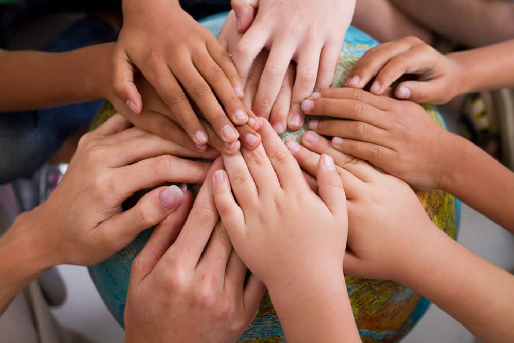 diversity kids hands together on globe